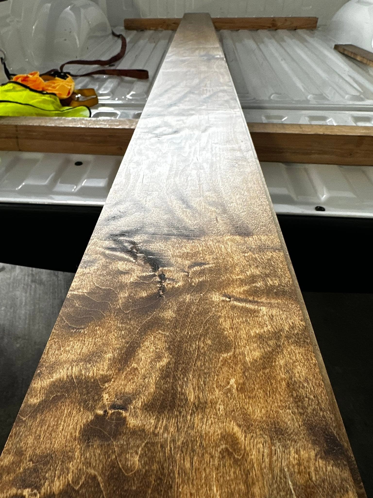 Raw hardwood lumber staged in the truck bed, ready for custom cabinetry